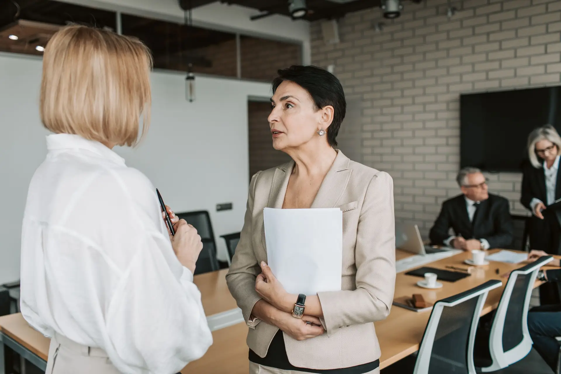 Two colleagues in conversation during a meeting in a bright office
