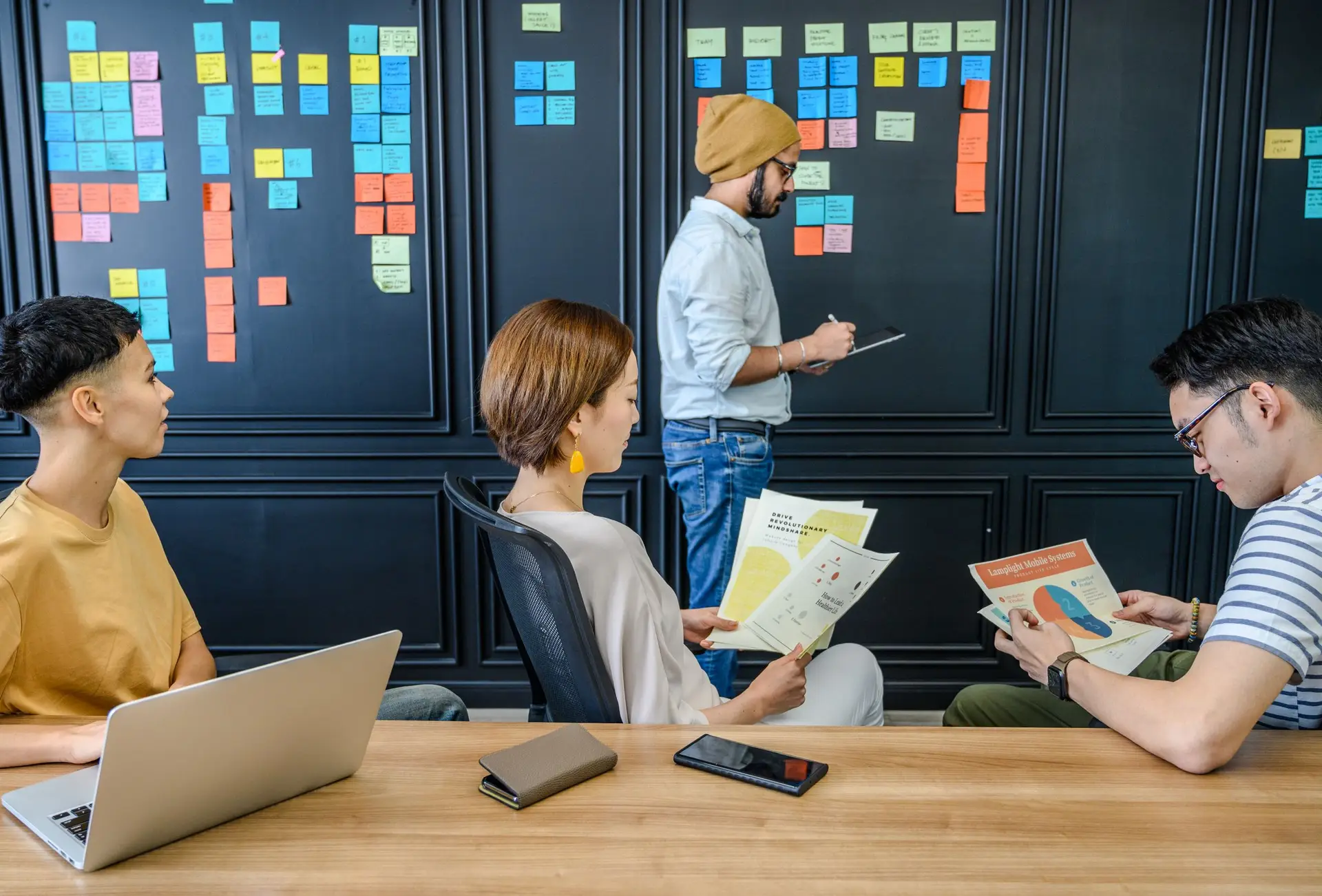 Colleagues organizing ideas with sticky notes and documents