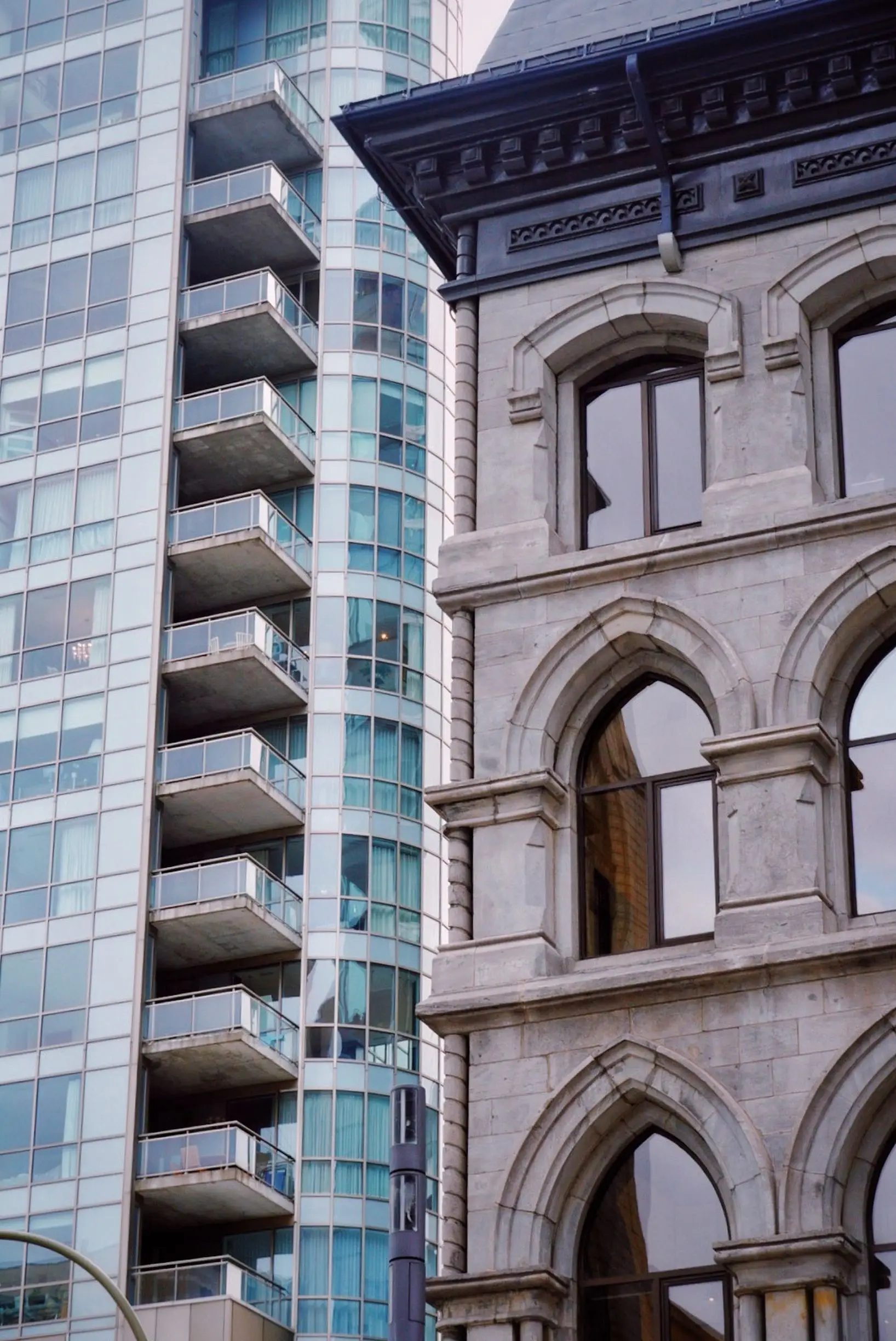Historic stone building beside modern glass towers in Montreal