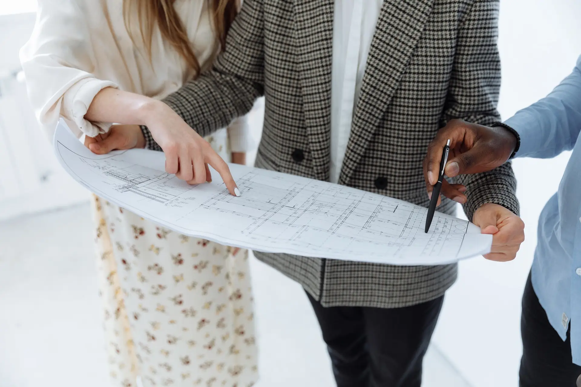 People reviewing building floor plans at a table